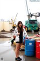 A woman standing in front of a bunch of barrels.