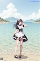 A woman in a maid outfit standing on a beach.