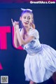 A woman in a white dress dancing on a stage.