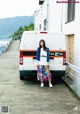 A woman standing in front of a white van.