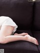 A woman laying on a couch with her legs crossed.