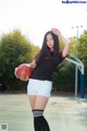 A woman holding a basketball on a basketball court.