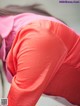 A woman in a pink shirt is bending over.