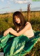 A woman sitting in a field of tall grass.