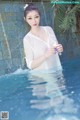 A woman in a white shirt is standing in a pool.