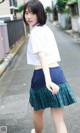 A young woman in a school uniform is walking down the street.