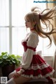 A woman in a red and white dress sitting on a window sill.