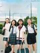 A group of young women in school uniforms posing for a picture.